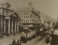 Horses & carts going past buildings by Unknown